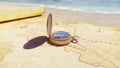 Pirate compass on the Treasure Map lying on the sand on the island of pirates. Vintage beautiful pirate compass lying on Royalty Free Stock Photo