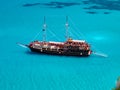 Pirate corsair style boat ship in amazing Greece island bay with swimming people, beach in Ionian Sea blue water, Greece islands h