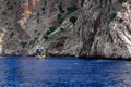 Pirate schooner in the blue sea against the backdrop of a rocky cliff