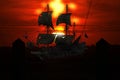 A pirate ship lays at anchor in a mystical Caribbean harbor-town