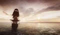 Pirate ship sailing on the ocean at sunset Royalty Free Stock Photo