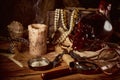 Pirate still life with candle, compass, dark rum in a skull bottle and old papers