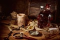 Pirate still life with candle, compass, dark rum in a skull bottle and old papers