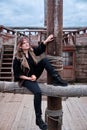 A pirate woman sits with an apple in her hand near the mast of an old robber sailing ship Royalty Free Stock Photo