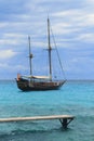 Pirates inspired wood sailboat anchored turquoise Royalty Free Stock Photo