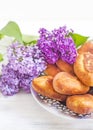 Piroshki - russian baked puff pastry with cabbage fillings and bouquet of lilacs. Traditional russian cabbage stuffed baked pastry Royalty Free Stock Photo