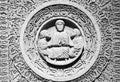 Close-up on religious sculptures carved in round frame in stone wall