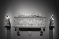 Black and white photo of medieval marble tomb surrounded by decorative statues