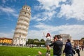 Tourists posing and taking pictures in front of the famous Leaning Tower of Pisa Royalty Free Stock Photo