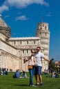 Young couple of tourists taking a selfie in front of the famous Leaning Tower of Pisa Royalty Free Stock Photo