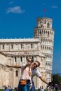 Young couple of tourists taking a selfie in front of the famous Leaning Tower of Pisa Royalty Free Stock Photo