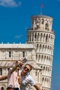 Young couple of tourists taking a selfie in front of the famous Leaning Tower of Pisa Royalty Free Stock Photo