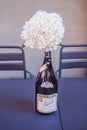 Bouquet of white flowers in a Rinaldi barolo 2007 red italian wine bottle