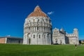 Pisa, Italy - 25 June 2018: Pisa Baptistery Battistero di Pisa on Piazza del Miracoli Duomo square,Camposanto cemetery, leaning Royalty Free Stock Photo