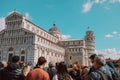 Pisa, Italy - March 18, 2023: Tourists packing the cathedral of Santa Maria Assunta and leaning tower in Piazza dei