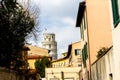 Pisa, Italy - March 17, 2012: Tower of Pisa is visible above street roofs. Torre di Pisa is a freestanding bell tower of the