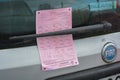 A pink paper document, a fine from italian police. A parking ticket from transport coordinators. Back-window of car Fiat Royalty Free Stock Photo