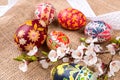 Pisanki with cherry blossom and white ribbon on sackcloth. Easter eggs in ethnic style. Easter eggs on canvas.