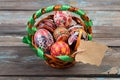 Pisanky in a wicker basket on a wooden background. Easter eggs on a wooden table. A busket with holiday eggs and blank