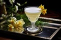 pisco cocktail garnished with flowers and greenery on a tray