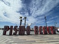 Pismo Beach sign under a cloudy blue sky in Pismo California