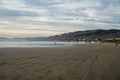 Pismo State Beach, California. Seashore, mountains, Pacific ocean, and cloudy sky on background Royalty Free Stock Photo