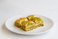 Pistachio baklava dessert on a white background. Turkish sweet dessert. Plate of pistachio baklava Royalty Free Stock Photo