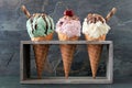 Pistachio, cherry and vanilla ice cream in waffle cones over slate Royalty Free Stock Photo