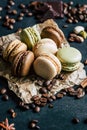 Pistachio chocolate coffee and vanilla flavored macaroons with pieces of chocolate cinnamon sticks coffee beans and pistachios Royalty Free Stock Photo