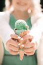 Pistachio ice cream in the hands of a girl. Waffle cup and ice c Royalty Free Stock Photo