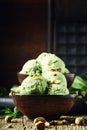 Pistachio ice cream with nuts, decorated with mint leaves, vintage wooden background, selective focus Royalty Free Stock Photo