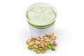 Pistachio ice cream in paper cup among the pistachio nuts Royalty Free Stock Photo