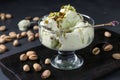 Pistachio ice cream with pistachio nuts glass ice-cream bowl on a dark background, horizontal photo