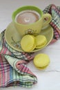 Pistachio macaron macaroon cookie dessert from France, vertical photo with coffee cup