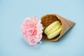 Pistachio macaron with pink flower in waffle cone