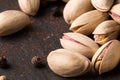 Pistachio nuts on a black background. Close-up of fresh pistachios and spicy pepper. Restaurant appetizers. Copy space.