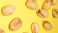 Pistachio nuts fall on a yellow background, they are rich in vitamins A, B1, B2, B3, E and K