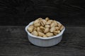 Pistachio Nuts in a white dish on a rustic background Royalty Free Stock Photo