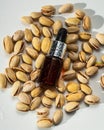 Pistachio oil in a glass bottle with nuts on a white background. Natural cosmetics on a white background. Aroma oils. Royalty Free Stock Photo