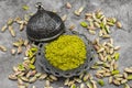 Pistachio powder on dark background. It`s surrounded by pistachios. close-up