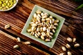 Pistachio in a square plate on wood surface Royalty Free Stock Photo