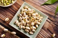 Pistachio in a square plate on wood surface Royalty Free Stock Photo