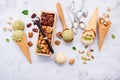 Pistachio and vanila ice cream in cones with mixed nut setup on white stone background . Summer and Sweet menu concept