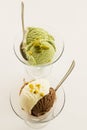 Pistachio and vanilla ice cream in glass bowls on white surface Royalty Free Stock Photo