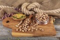 Pistachios briefly in copper bowl on wooden rustic background, wonderful pistachio composition for healthy and dietary nutrition.