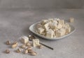 Pistachios halvah in plate with pistachios nuts on gray background