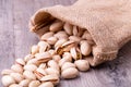 Pistachios nut in burlap sack on grained wood background Royalty Free Stock Photo