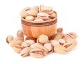 Pistachios pouring out of wooden bowl isolated on white background Royalty Free Stock Photo