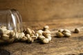 Pistachios scattered on the wooden vintage table from a jar. Pistachio is a healthy vegetarian protein nutritious food