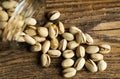 Pistachios scattered on the wooden vintage table from a jar. Pistachio is a healthy vegetarian protein nutritious food